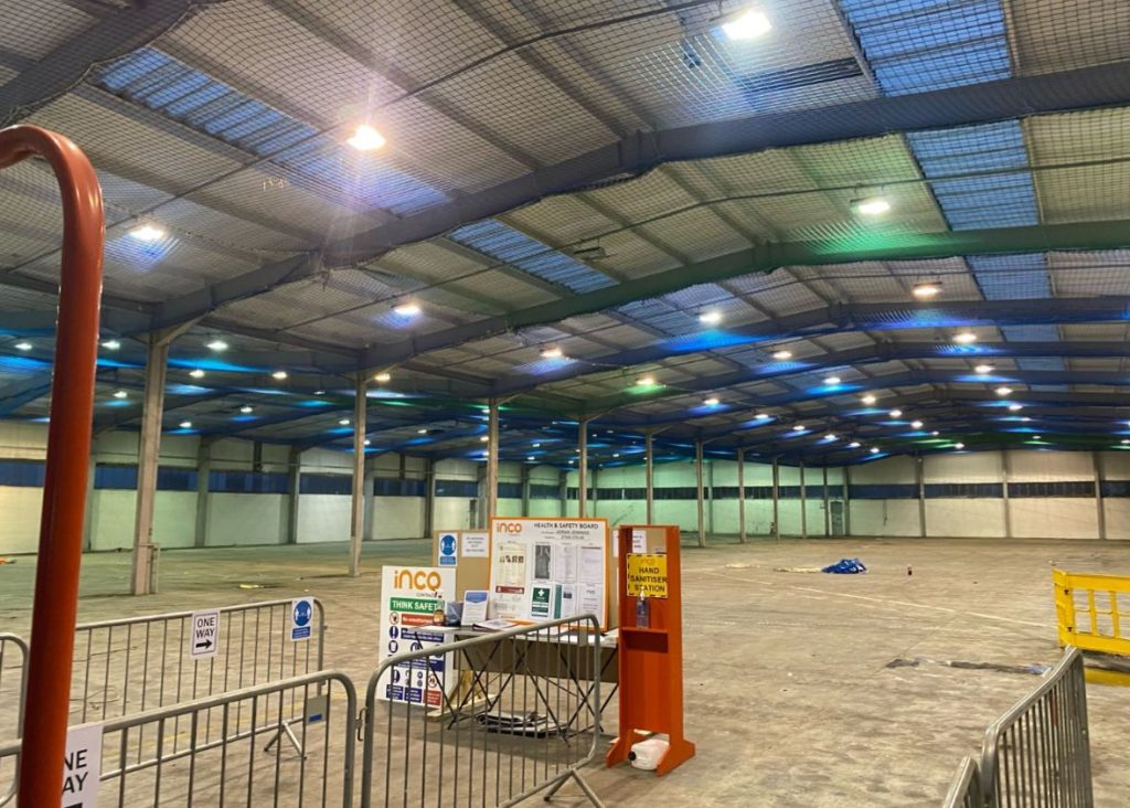 picture of an empty warehouse with scaffolding and safety netting